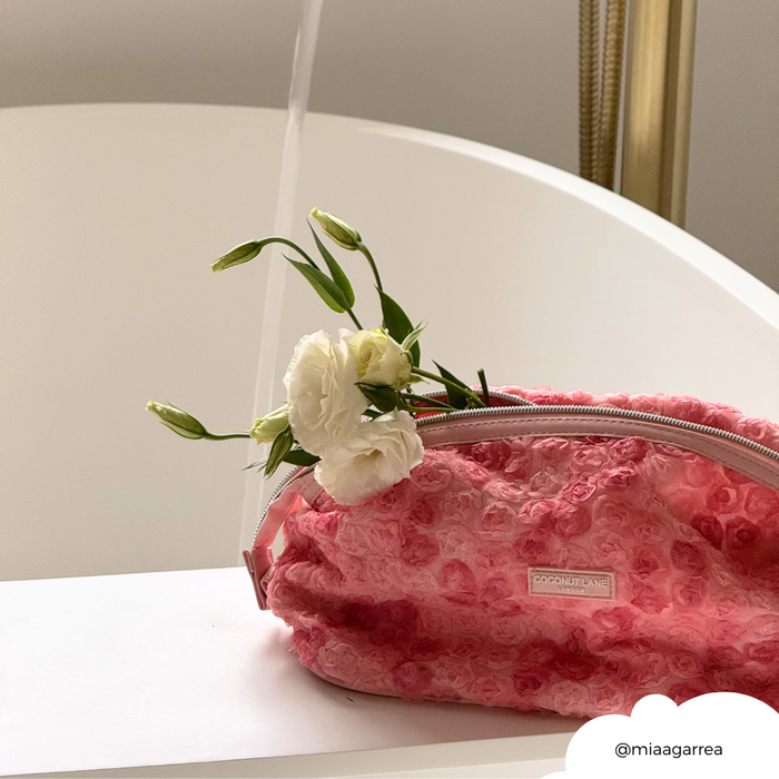 Coconut Lane expandable pink floral makeup bag beside a white tub with running water.