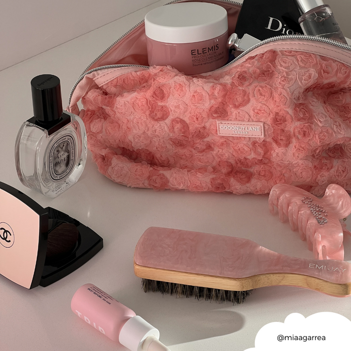 Coconut Lane expandable makeup bag in Peony Bloom, pink floral pattern, open with beauty products, brush, and clips inside.
