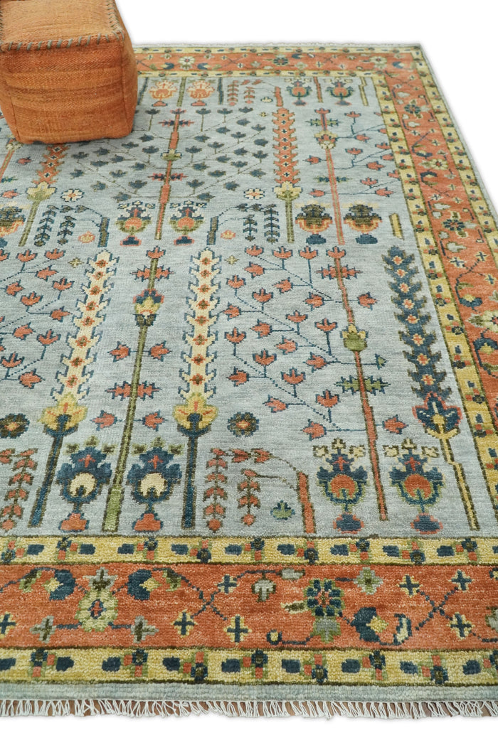 Hand-knotted wool rug with Tree of Life pattern, blue and rust, fringe edges.