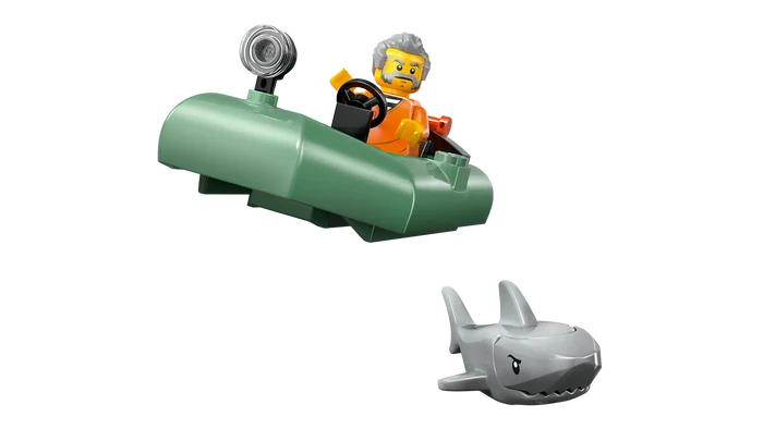 Toy submarine with a figure inside and a shark model on a white background