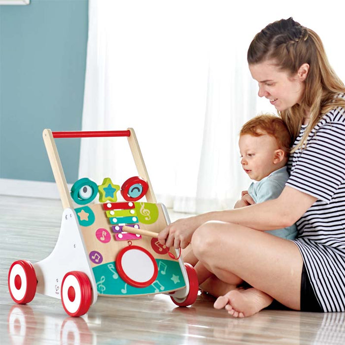 Mother and child seated playing with the musical instruments on My First  Musical Walker