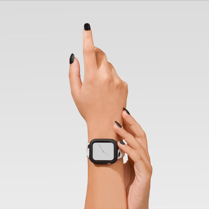 Hand wearing a black Coconut Lane silicone Apple Watch case; other hand pointing up against a light background.