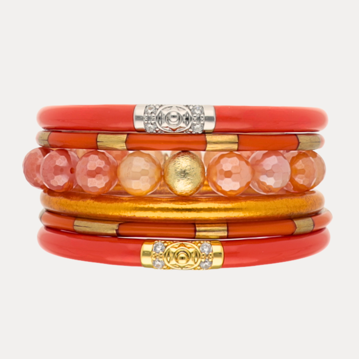 a stack of orange and gold bracelets