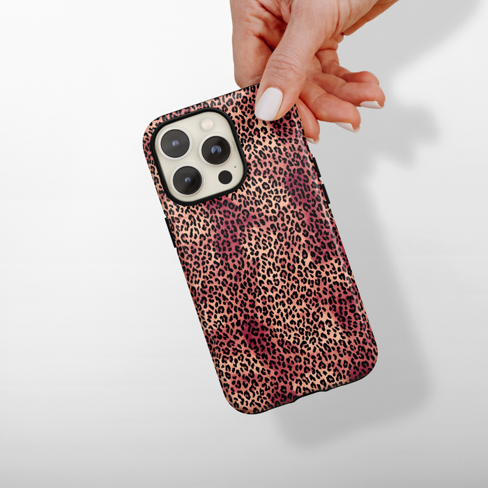 Hand holding a pink and brown leopard print Coconut Lane Tough Phone Case against a white background.